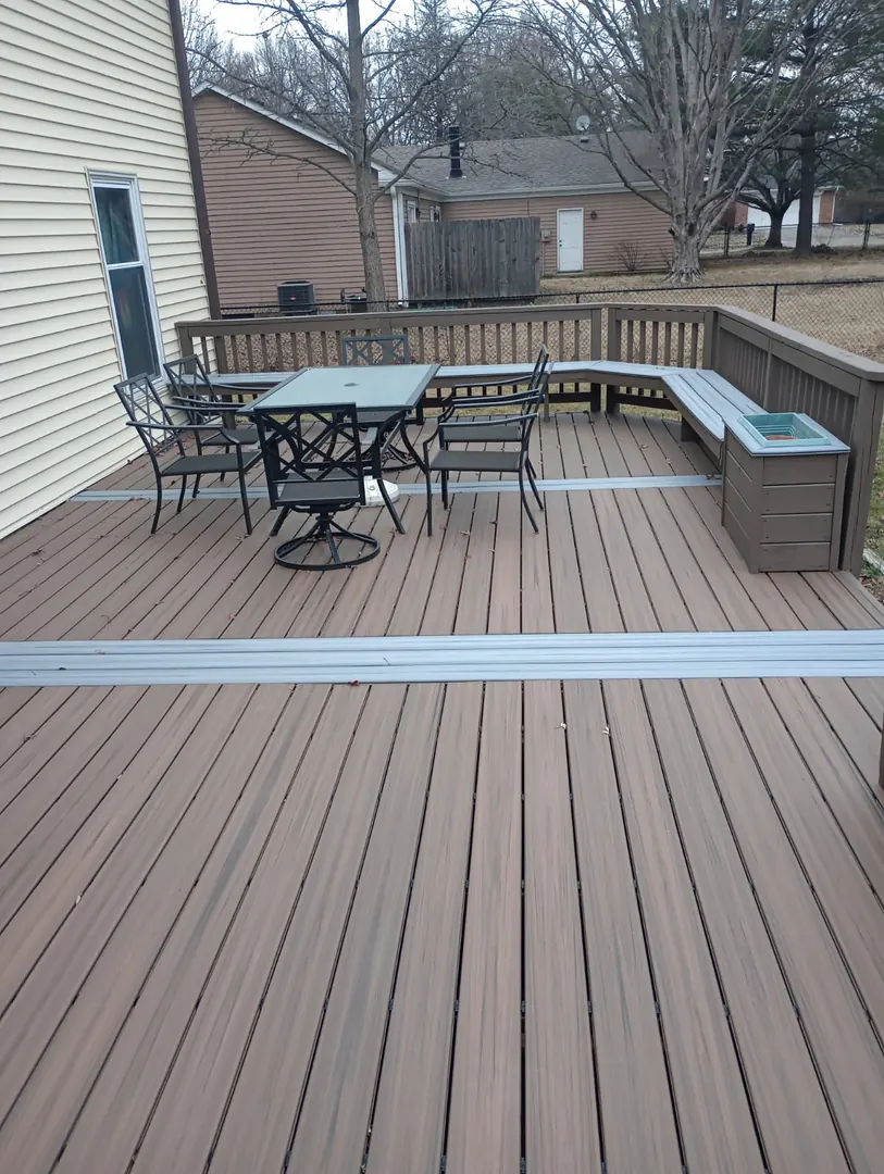 New composite deck with a patio table set and built-in bench along the railing