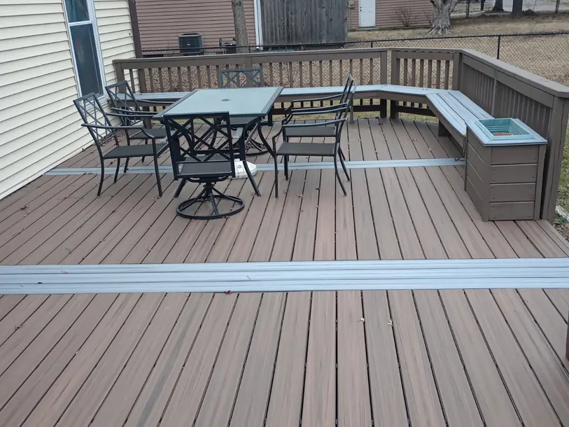 Finished composite deck with built-in bench seating and a patio table set