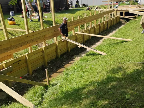 Crew framing a raised deck beside a backyard gazebo