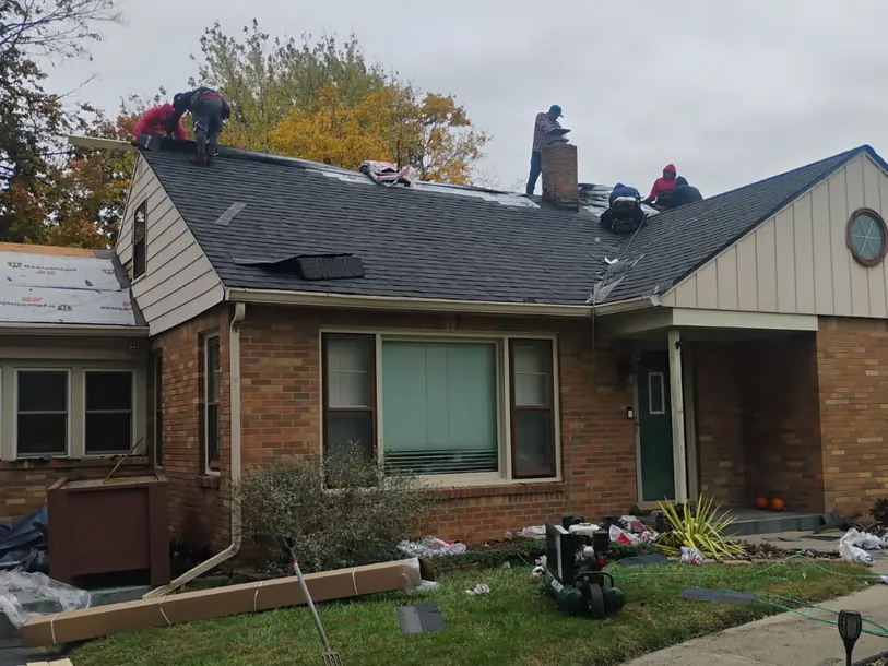 Roofing crew working on the roof of a brick ranch house