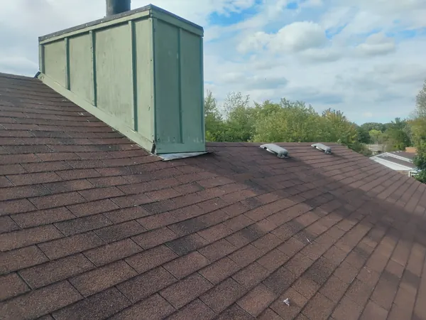 Chimney with new metal cladding on a brown shingle roof