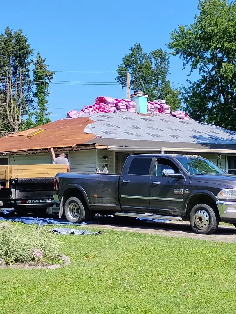 Ranch house mid tear-off with new underlayment down and shingle bundles staged on the ridge
