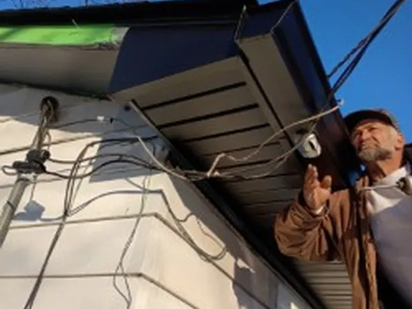 Installer fitting soffit and gutter at a roof corner