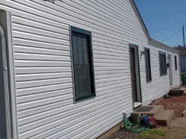 Side wall of a house in new white vinyl siding